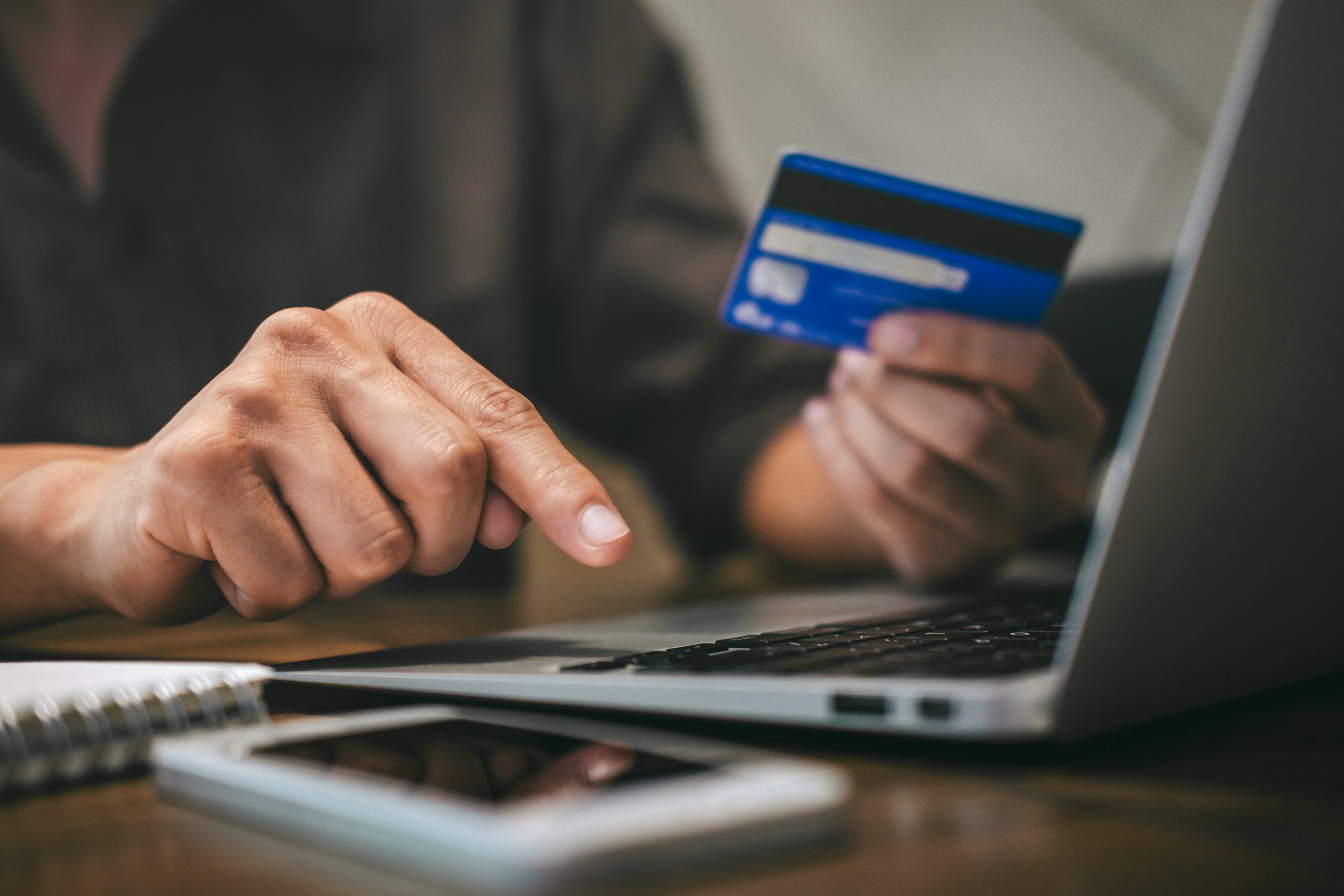 Condominium manager in Toronto, Ontario holding credit card and typing on a latptop.