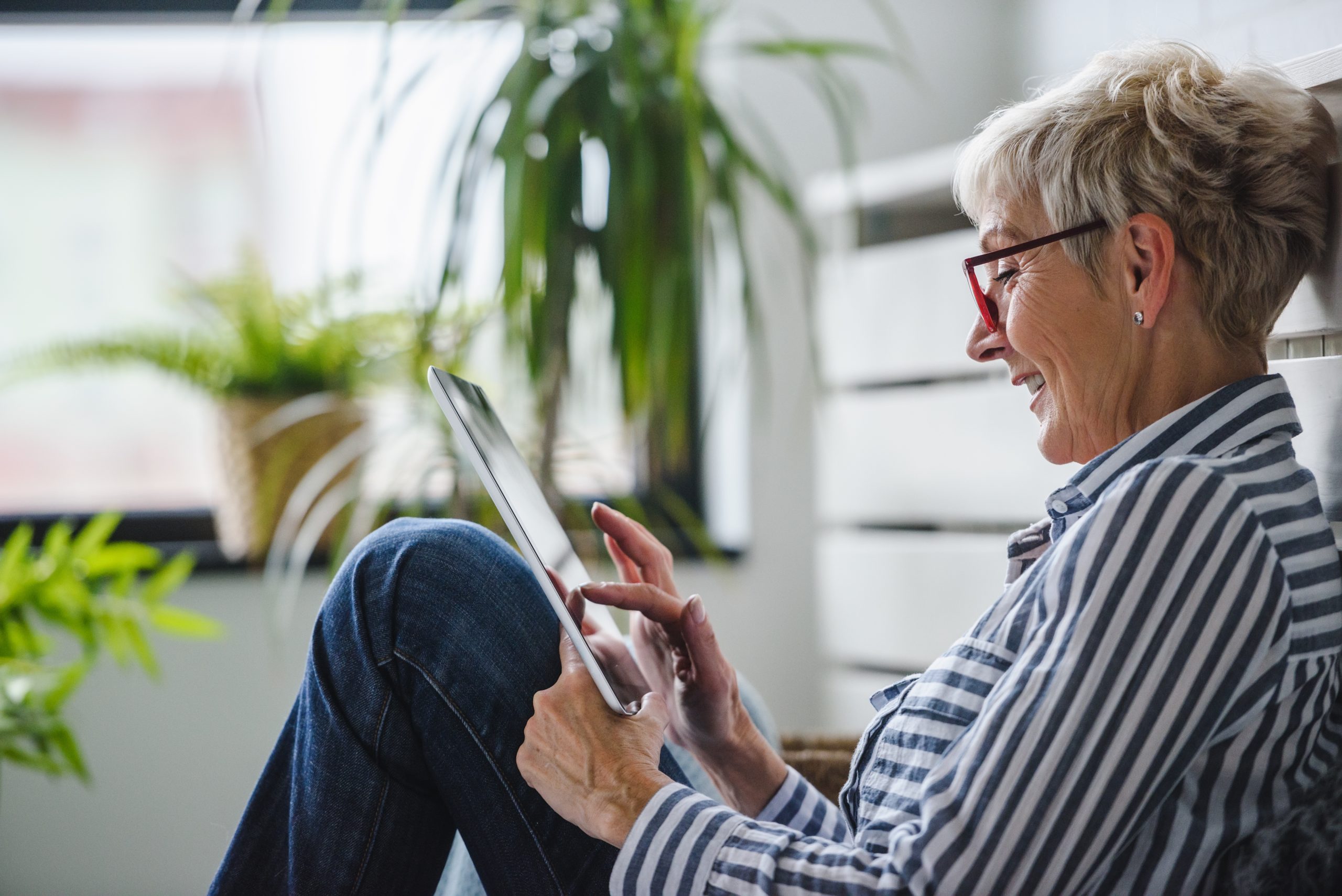 Senior woman using digital tablet in condominium unit in Toronto, Ontario.