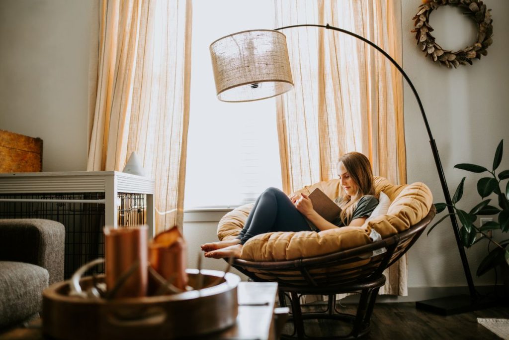 Woman sitting on a chair reading in a stacked townhouse open concept living room.