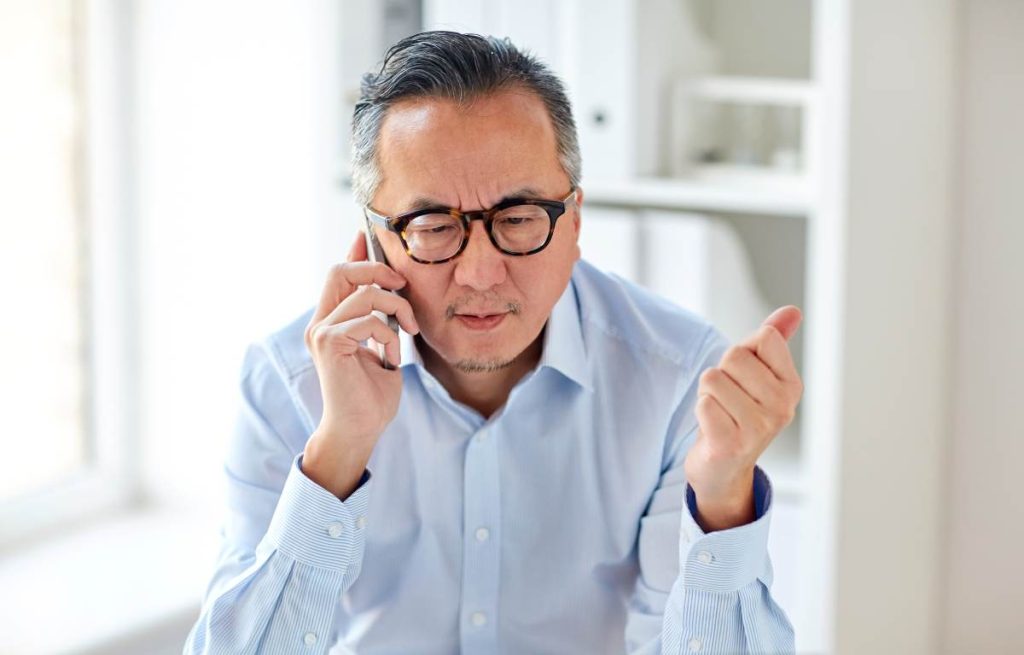 A condo management on the phone with the condo property management company looking frustrated due to a communication breakdown.